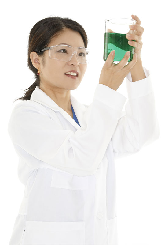 photo of female pharma employee wearing white lab coat examining beaker